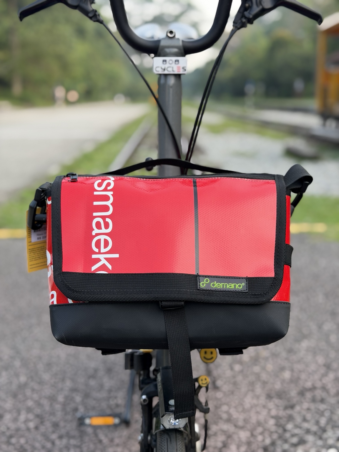 Red and white Demano Ribera 1701 6L mini front bag mounted on a Brompton, viewed from the front