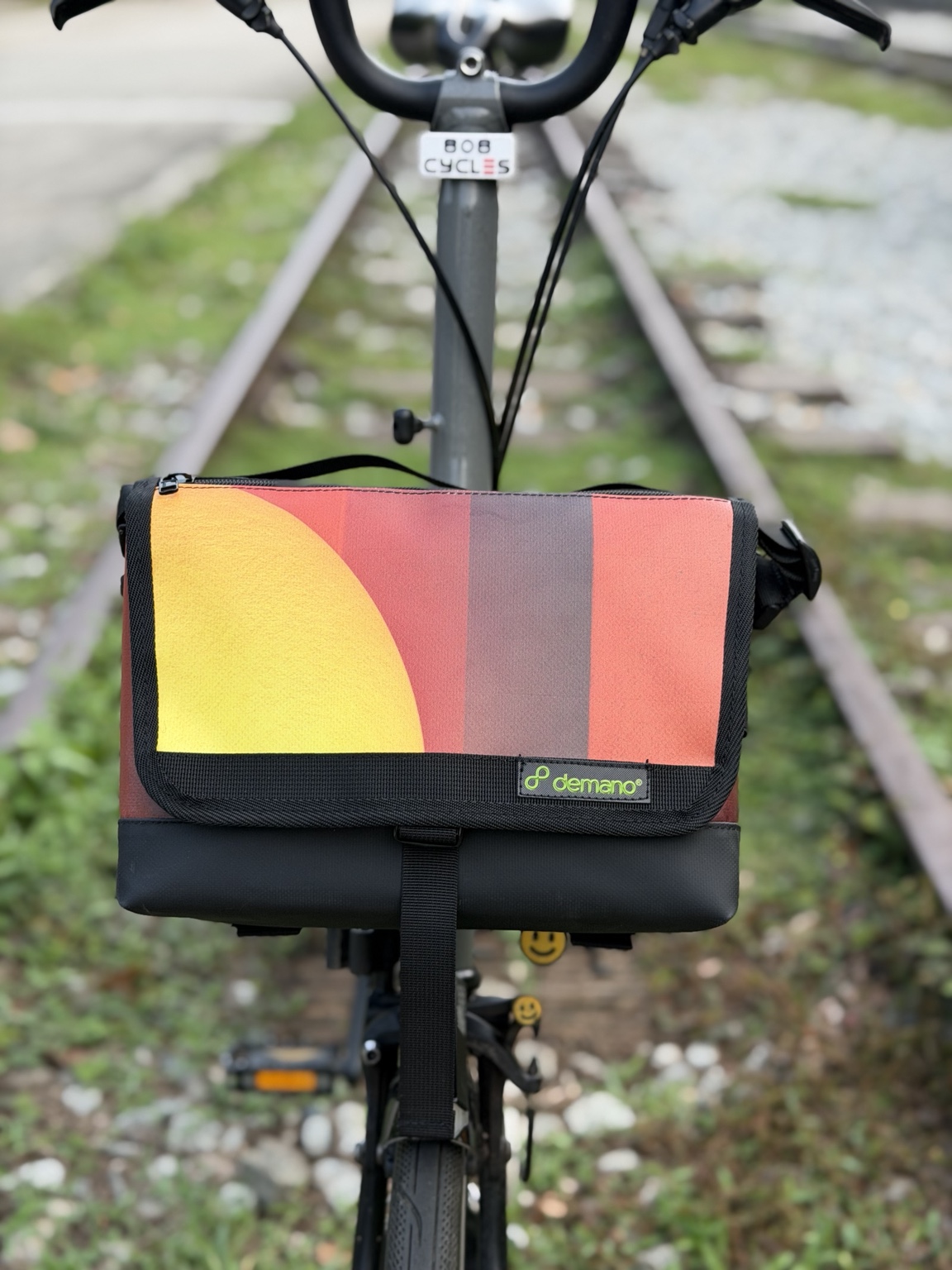 Demano Ribera 1702 with yellow, coral and charcoal panels mounted on a Brompton