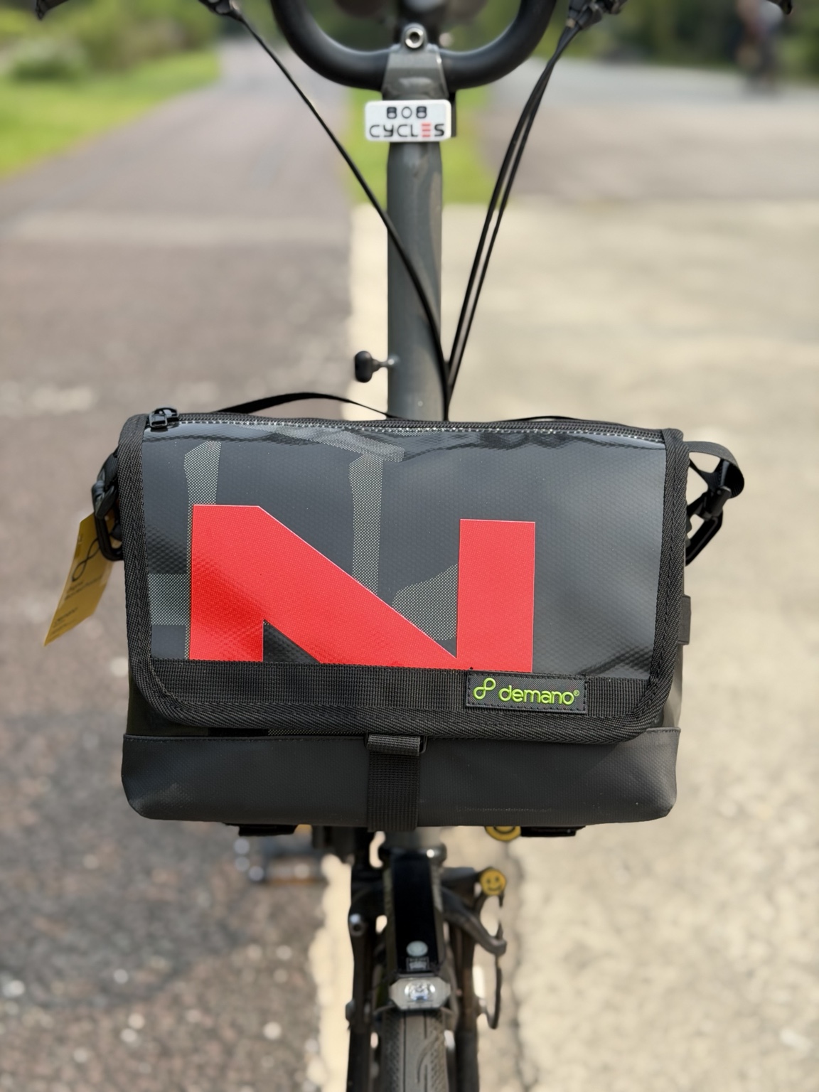 Front view of the actual black-and-red Demano Ribera 1704 bag mounted on a Brompton.