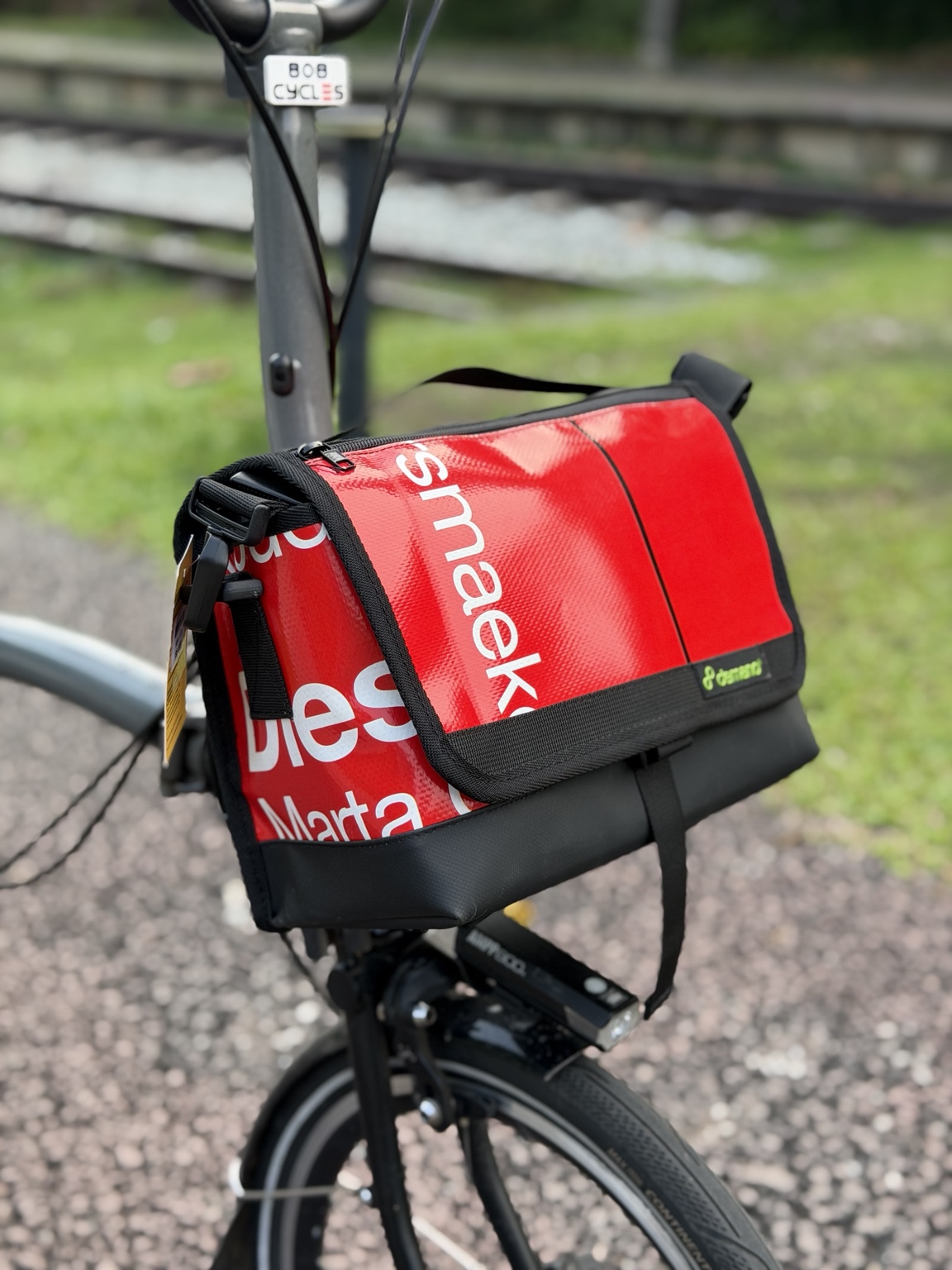 Left front angle of Demano Ribera 1701 red and white mini front bag on a Brompton
