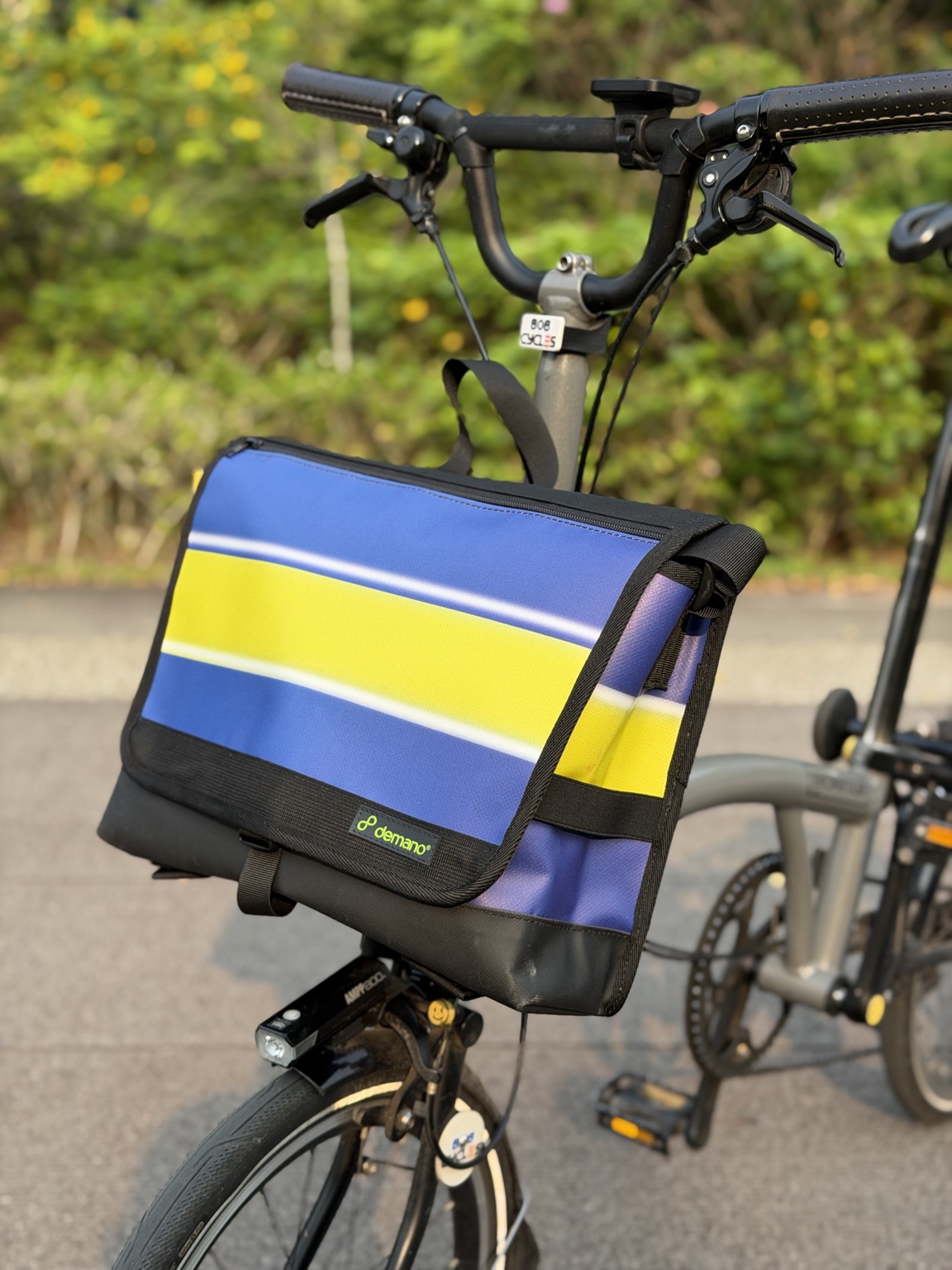 Right three-quarter view of Demano Arago 1711 with its blue-purple flap, broad yellow stripe, white outlines and black trim.
