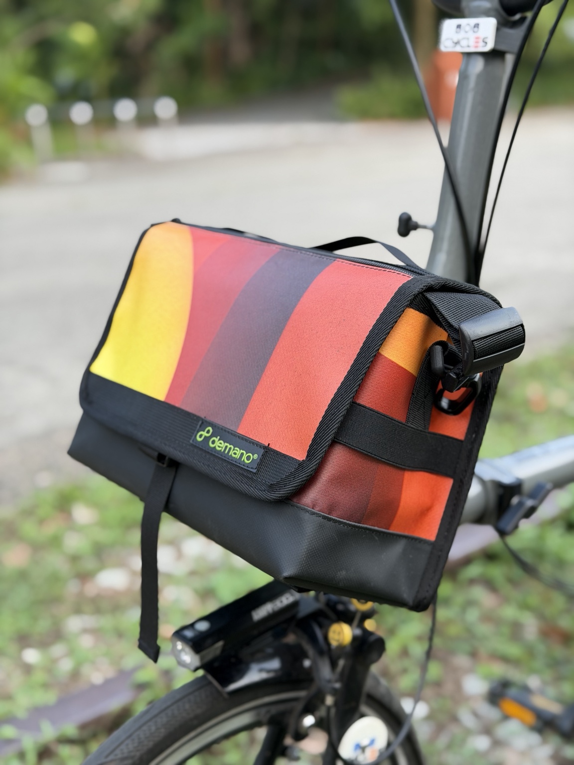 Right three-quarter view of Demano Ribera 1702 mounted on a Brompton with its side strap attachment visible