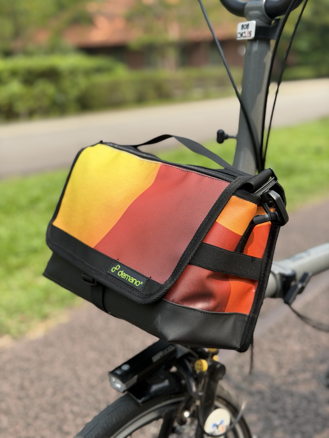 Right three-quarter view of Demano Ribera 1710 showing the yellow-orange and burgundy flap, orange-red side panel and black hardware.