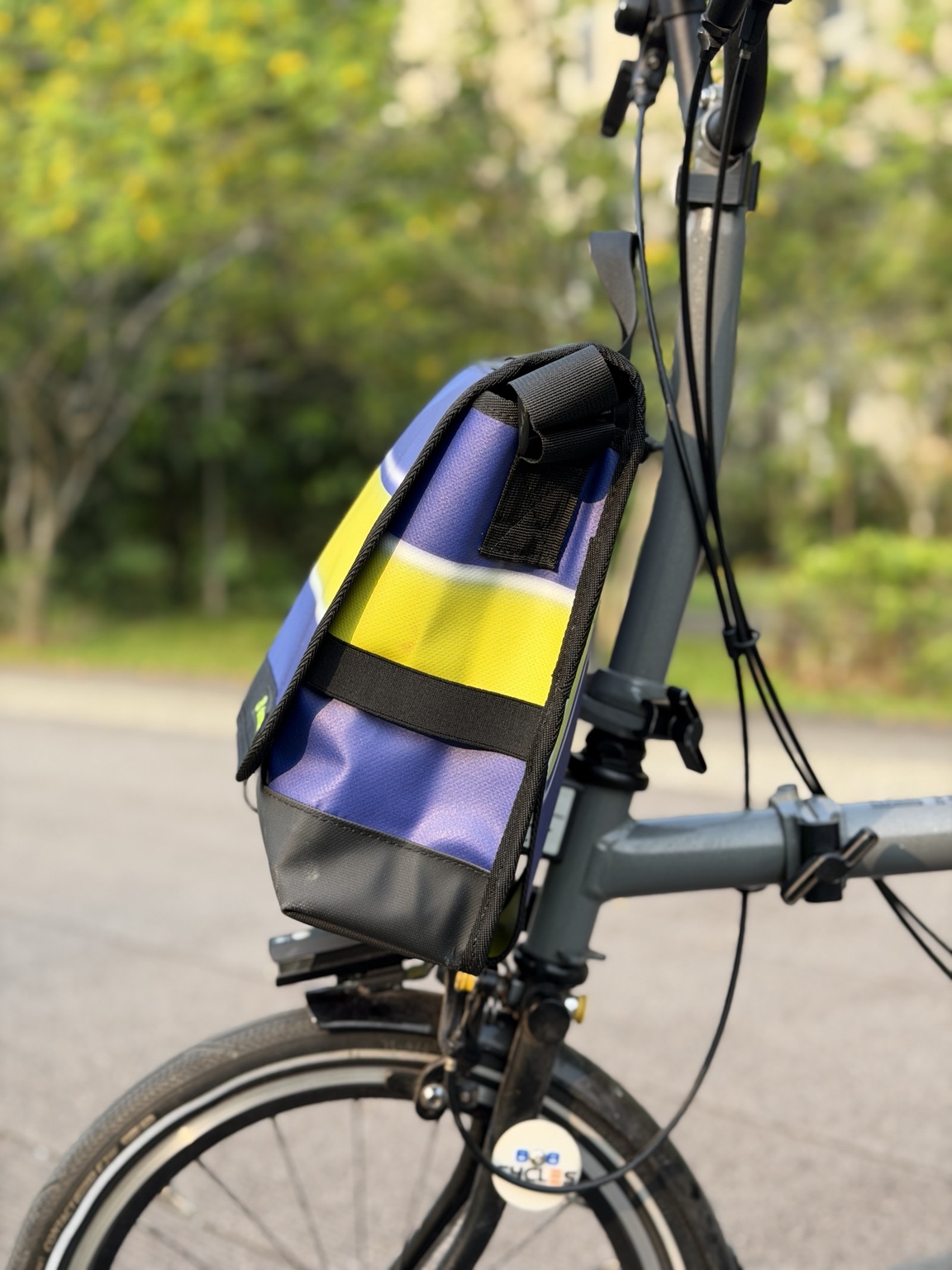 Right-side profile of Demano Arago 1711 showing blue-purple material, a yellow stripe, black webbing, elastic strap and reinforced base.