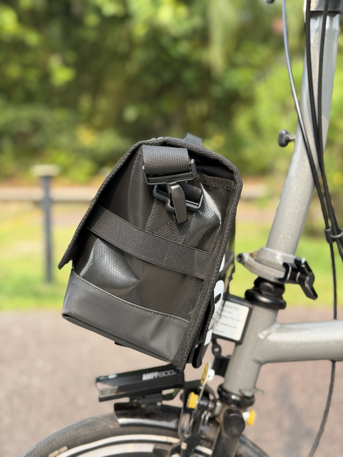 Right-side profile of Demano Ribera 1704 showing black strap hardware and horizontal webbing over glossy black PVC.