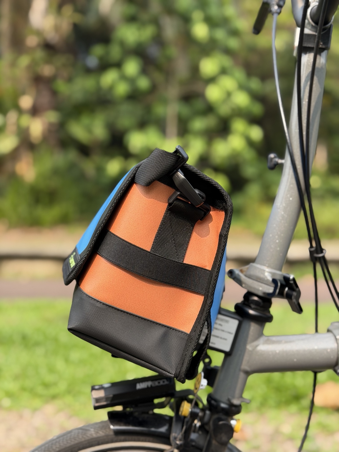 Right-side profile of Demano Ribera 1705 showing black strap hardware and horizontal webbing over an orange side panel.