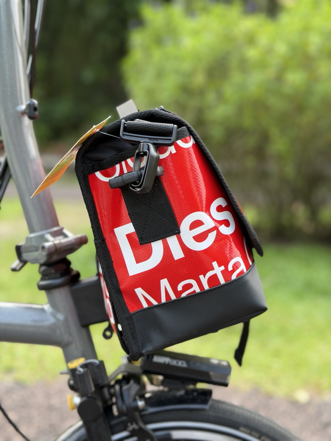 Red and white upcycled banner lettering and strap hardware on the side of Demano Ribera 1701