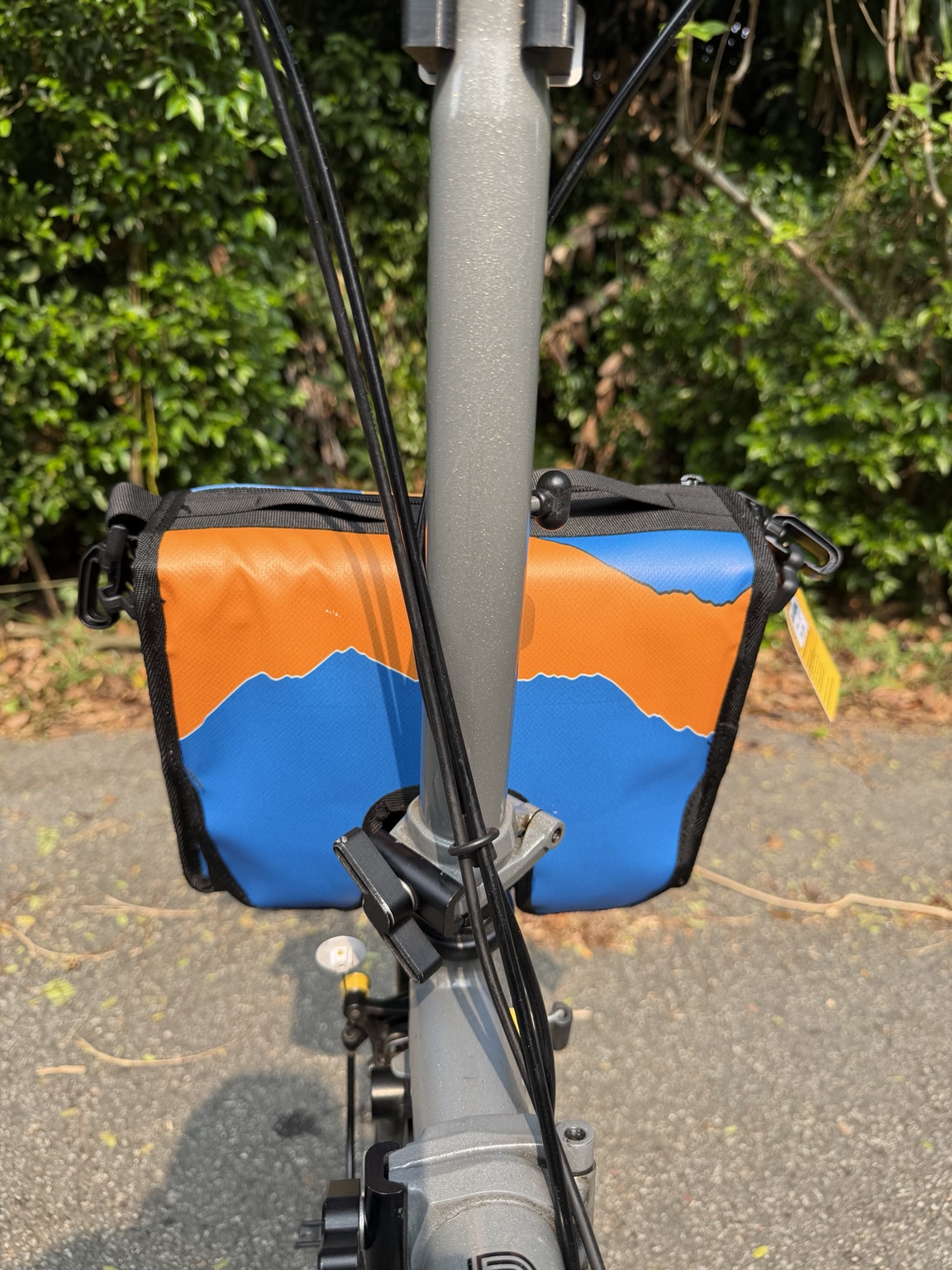 Blue-and-orange rear print of Demano Ribera 1706, partly obscured by the original Brompton stem and cables.