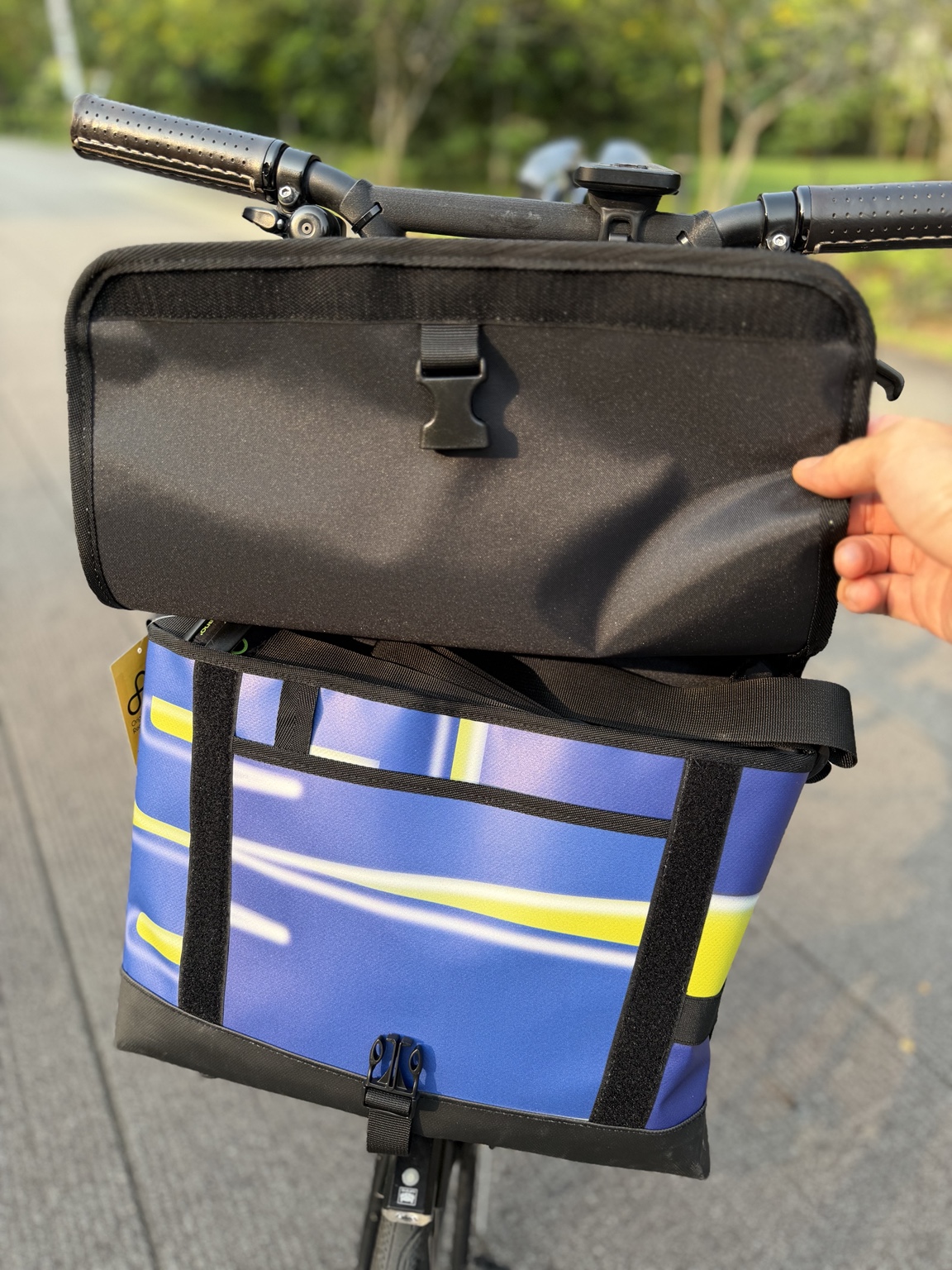 Actual Demano Arago 1711 with the flap held open, showing black lining, shoulder strap, front pocket, yellow-white banner stripes and front fastening.
