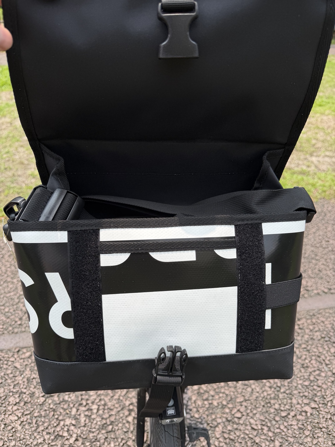 Actual Demano Ribera 1709 with the flap held open, showing black lining, shoulder strap, black-and-white printed panels and the front fastening.