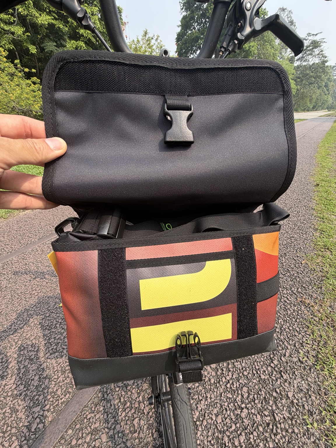 Actual Demano Ribera 1710 with the flap held open, showing black lining, shoulder strap, cropped yellow banner lettering and front fastening.
