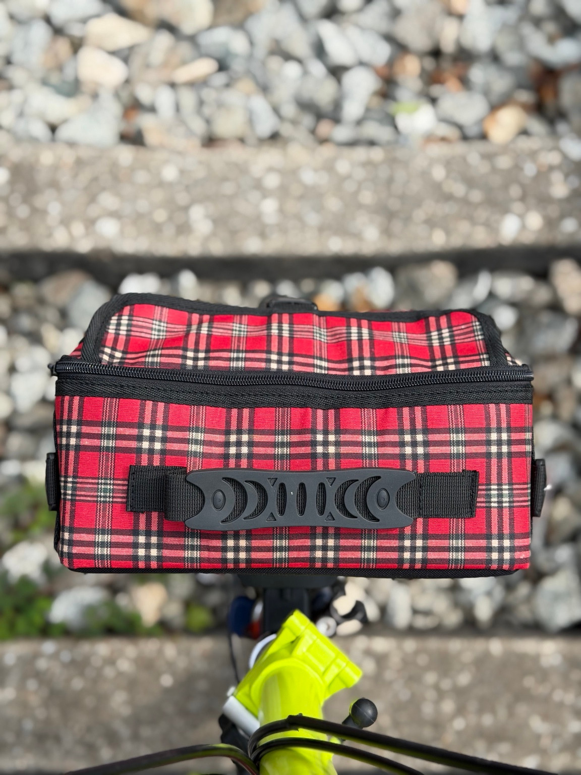 Top view of Valeria’s Cris Mini #04 showing the red tartan fabric, black carry handle and zipped opening