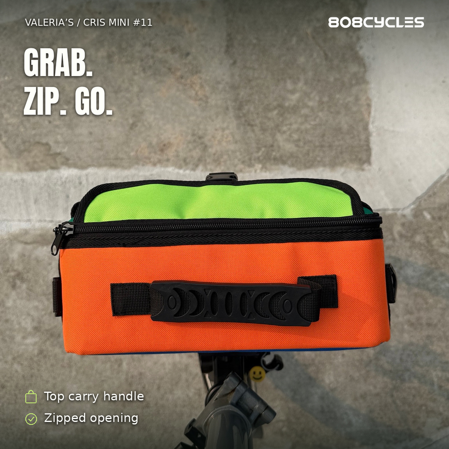 Feature graphic: Top view of Cris Mini #11 showing orange top, carry handle and lime flap
