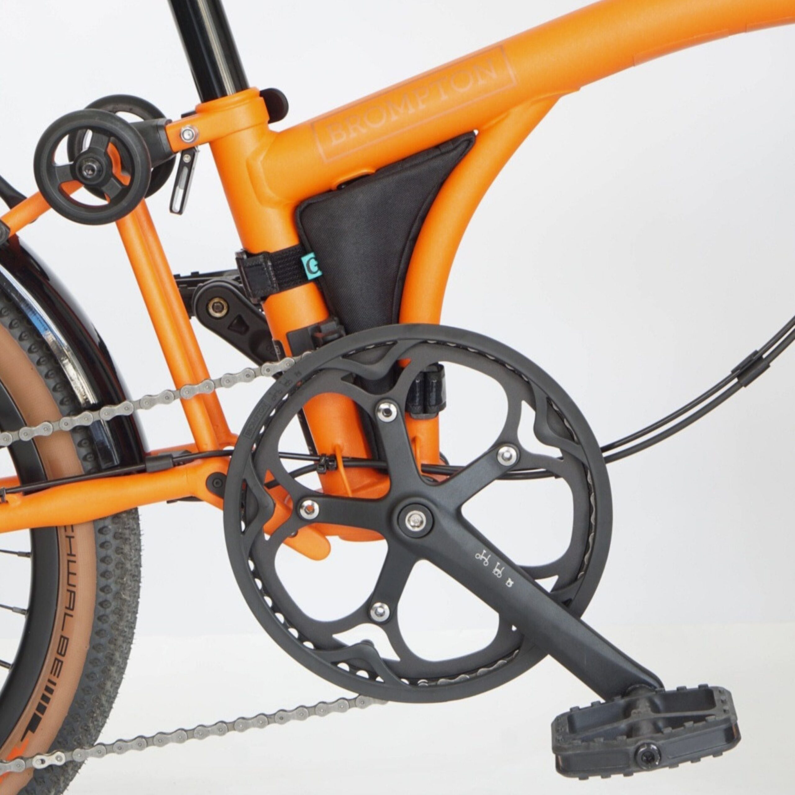 Opposite side of black Vincita Boomerang bag attached to the frame of an orange Brompton G Line